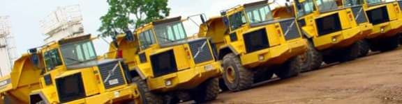 Rows of company-owned articulated dump trucks lined up on site